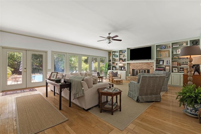 65 Byrnes Blvd, Mobile, AL 36608 - living area featuring french doors, ceiling fan, a brick fireplace, and light wood-style floors
