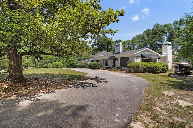65 Byrnes Blvd, Mobile, AL 36608 - view of front facade featuring curved driveway, a chimney, and a front yard