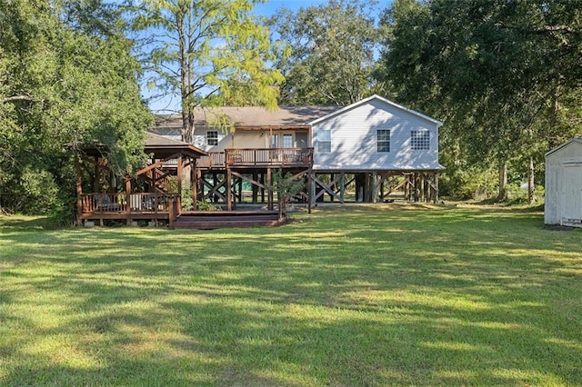 rear view of property featuring a gazebo, a wooden deck, a yard, and a storage unit