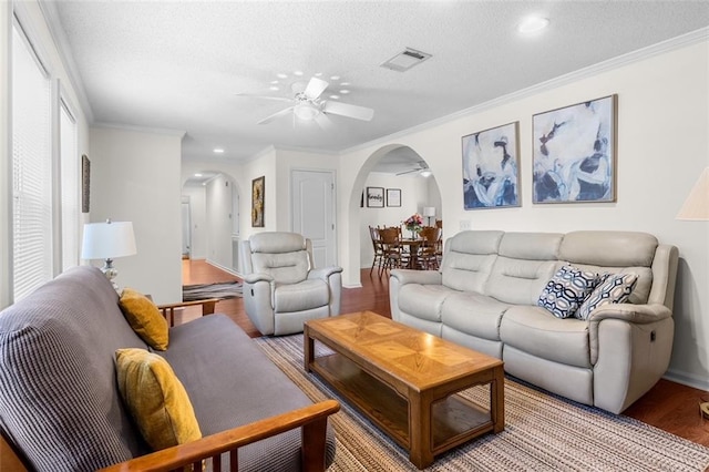 living room with wood-type flooring, ceiling fan, a textured ceiling, and crown molding