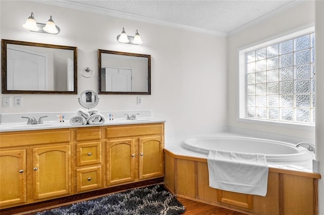 bathroom featuring a textured ceiling, a washtub, hardwood / wood-style floors, ornamental molding, and vanity