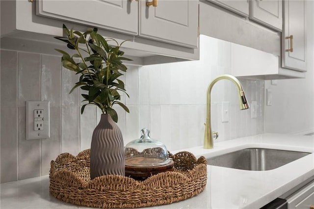 interior details featuring backsplash, light countertops, and a sink