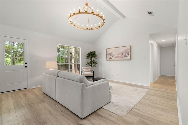 living area with a wealth of natural light, light wood-style flooring, and attic access