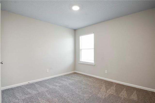 carpeted empty room with baseboards