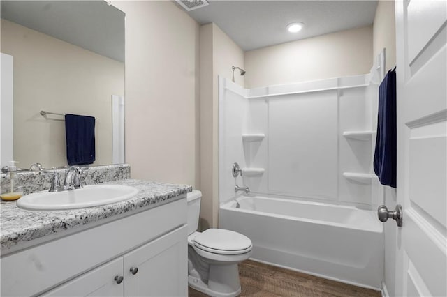 bathroom with visible vents, toilet, wood finished floors, vanity, and washtub / shower combination