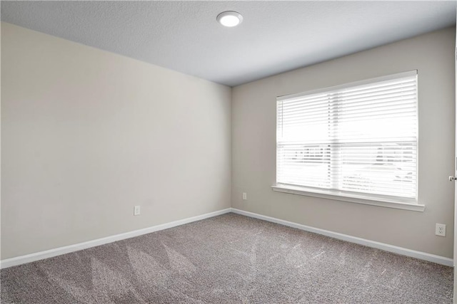 unfurnished room with carpet and baseboards