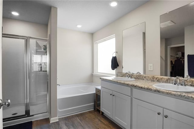 bathroom with a stall shower, a sink, and a bath