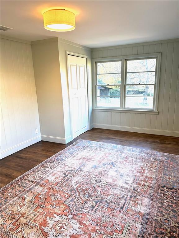 unfurnished bedroom with dark hardwood / wood-style flooring