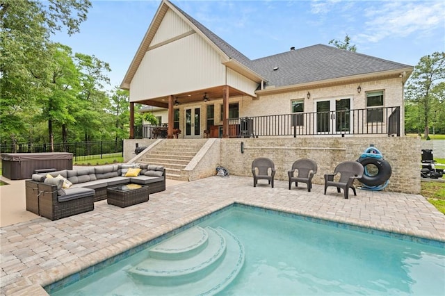 view of swimming pool with a hot tub, a ceiling fan, french doors, and a patio area
