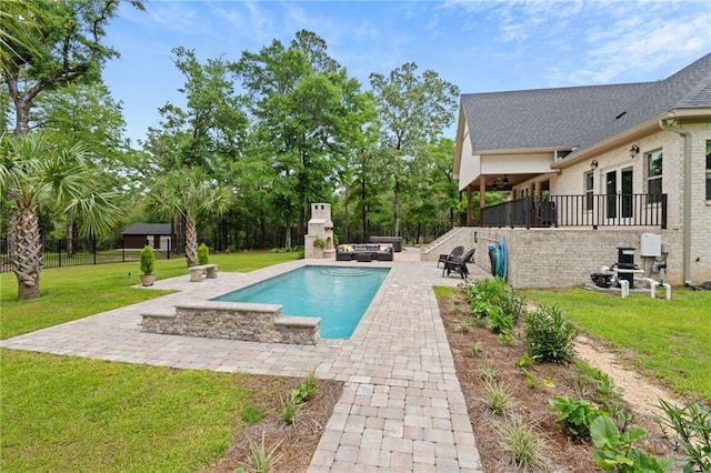 pool with a patio, an outdoor living space with a fireplace, and a yard