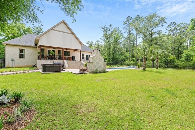 rear view of house featuring ceiling fan, a yard, a patio area, and an outdoor pool
