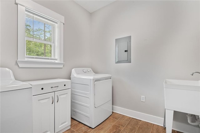 laundry room featuring independent washer and dryer, baseboards, wood finished floors, and electric panel