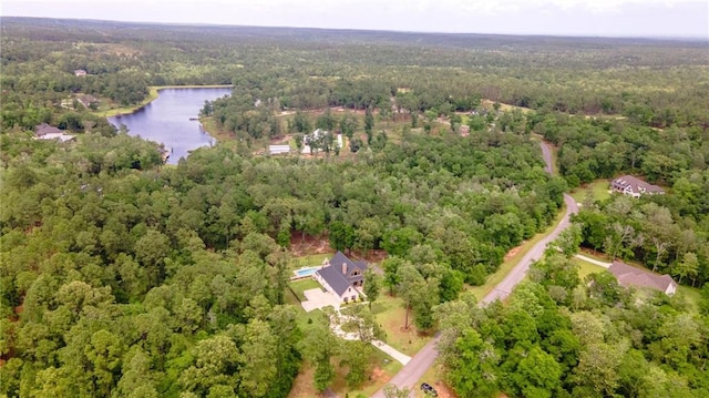 drone / aerial view featuring a water view and a wooded view