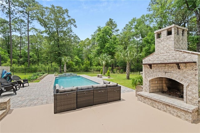 view of swimming pool featuring a lawn, an outdoor living space with a fireplace, fence, a fenced in pool, and a patio