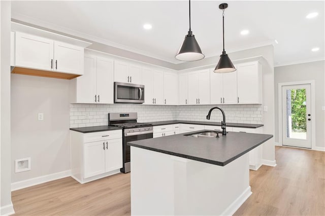 kitchen with a sink, dark countertops, stainless steel appliances, and light wood-type flooring
