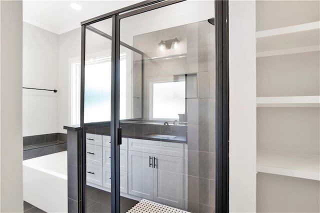 full bathroom featuring a garden tub, a stall shower, and vanity