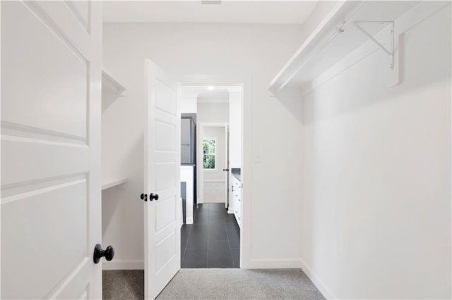 spacious closet with carpet floors and tile patterned floors