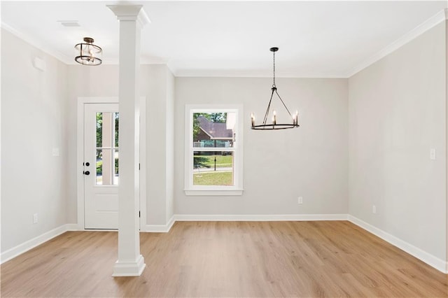 foyer featuring crown molding, light wood-style flooring, baseboards, and a chandelier