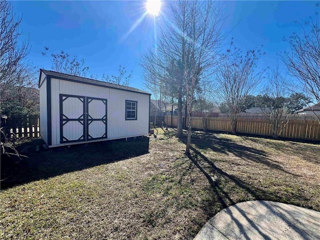 view of yard with a storage unit, an outdoor structure, and a fenced backyard