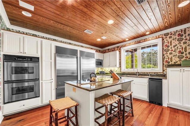 34460 Steelwood Ridge Rd, Loxley, AL 36551 - kitchen featuring wooden ceiling, stainless steel appliances, a kitchen bar, white cabinets, and light wood-style floors