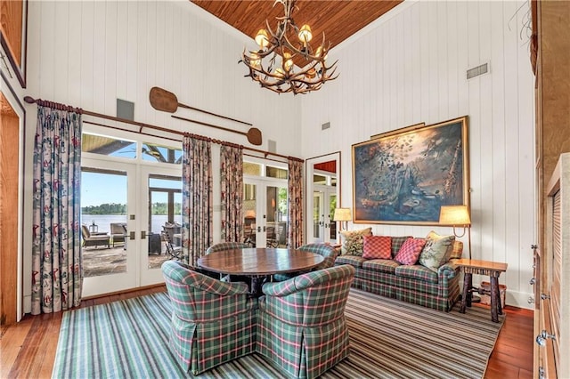 34460 Steelwood Ridge Rd, Loxley, AL 36551 - dining space featuring french doors, wood-type flooring, a towering ceiling, a chandelier, and a water view