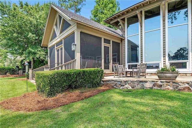 34460 Steelwood Ridge Rd, Loxley, AL 36551 - back of property featuring a sunroom, a lawn, a patio area, and a shingled roof