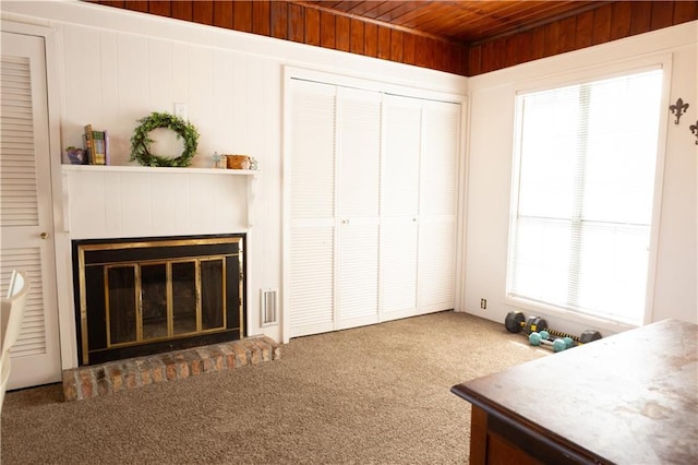 living room with wood ceiling and dark colored carpet