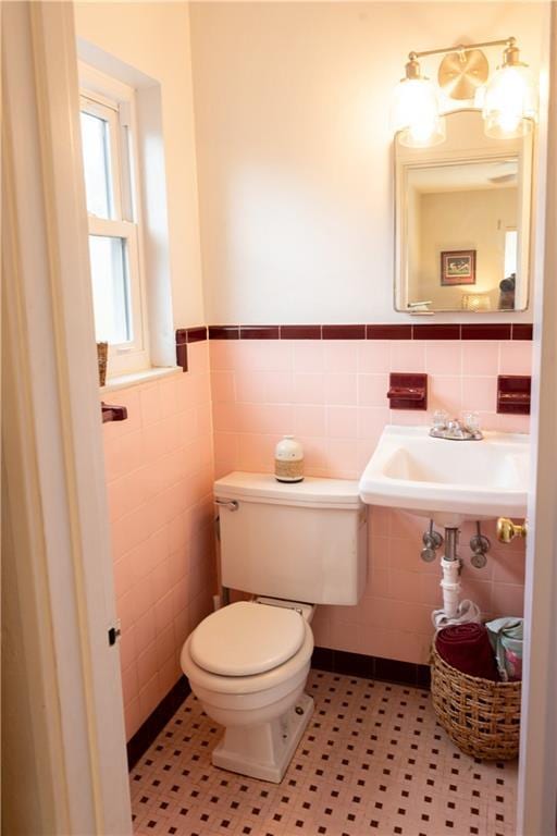 bathroom with sink, tile walls, and toilet