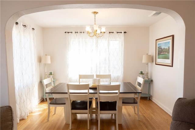 dining room with a notable chandelier and wood-type flooring