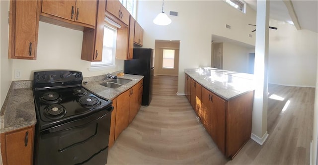 kitchen with stone counters, sink, decorative light fixtures, and black appliances