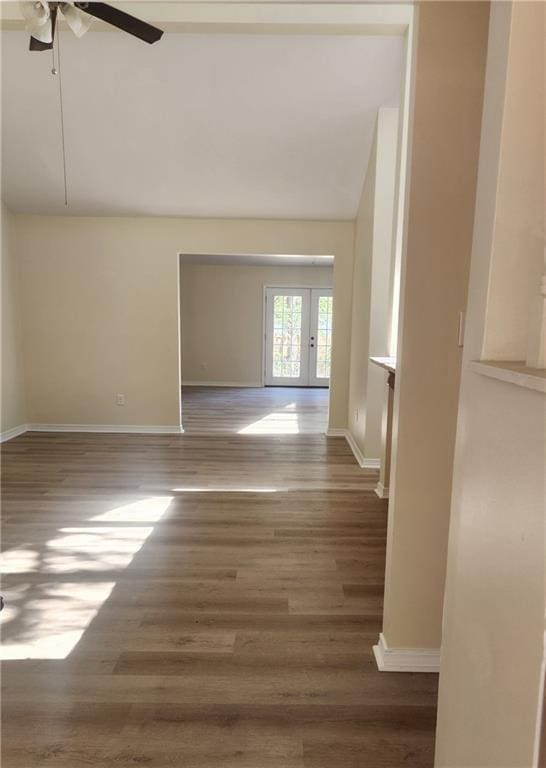 spare room with hardwood / wood-style floors, ceiling fan, lofted ceiling, and french doors