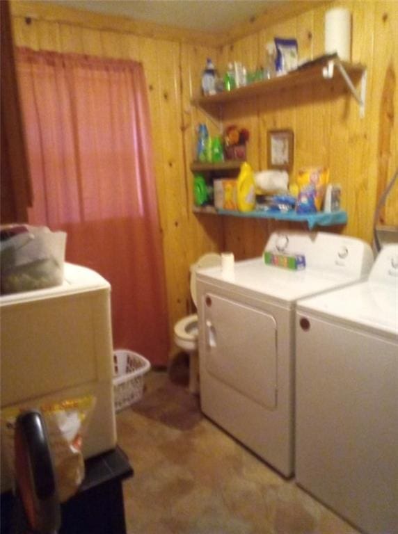 washroom with separate washer and dryer and wooden walls