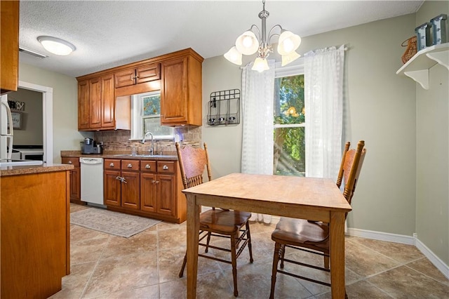 kitchen featuring hanging light fixtures, white appliances, an inviting chandelier, and plenty of natural light