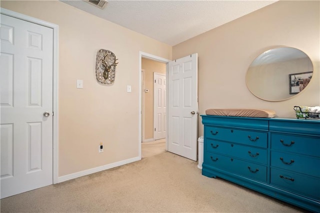 bedroom with a textured ceiling and light colored carpet