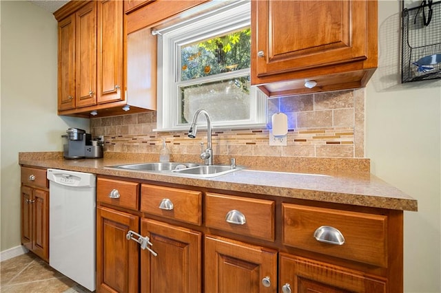 kitchen featuring decorative backsplash, dishwasher, and sink