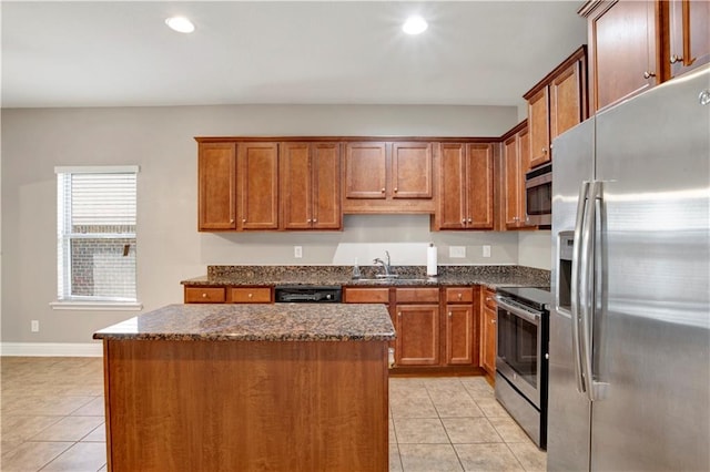 kitchen featuring light tile patterned floors, stainless steel appliances, a sink, and a center island