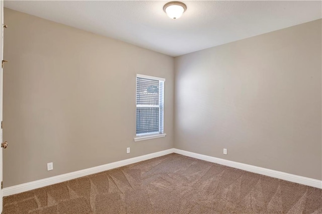 unfurnished room featuring carpet and baseboards