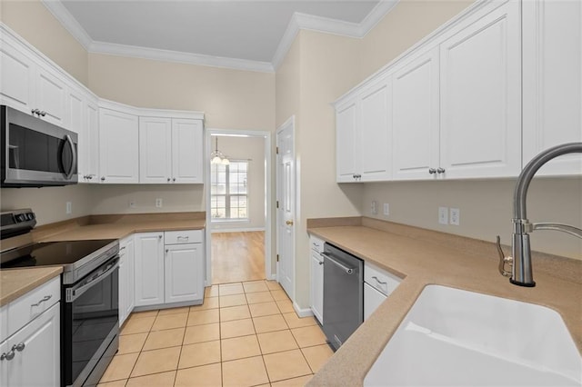 kitchen featuring light tile patterned flooring, crown molding, white cabinetry, and stainless steel appliances