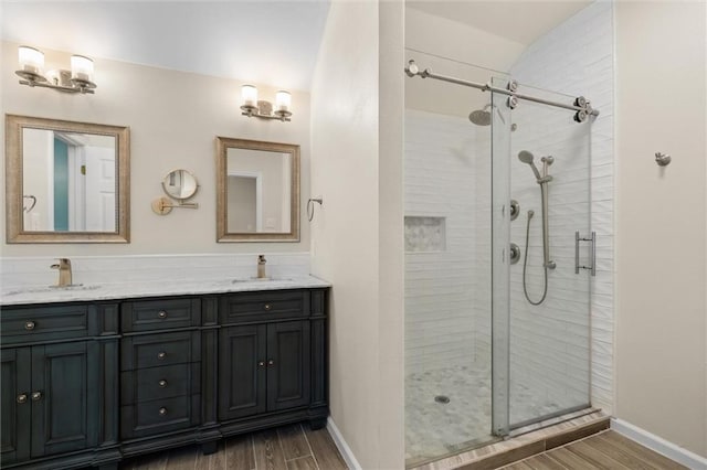 bathroom with a shower with door and vanity