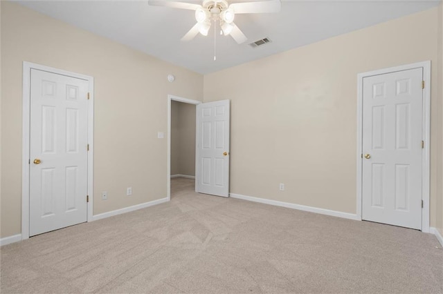 unfurnished bedroom featuring ceiling fan and light colored carpet