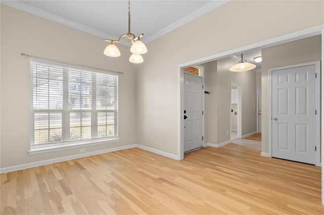 unfurnished dining area featuring a chandelier, crown molding, and light hardwood / wood-style floors