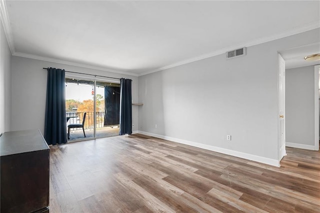 empty room with hardwood / wood-style flooring and ornamental molding