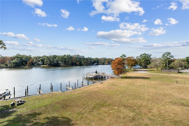 view of dock with a lawn and a water view