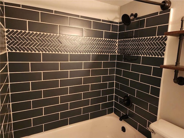 bathroom with tiled shower / bath combo and toilet