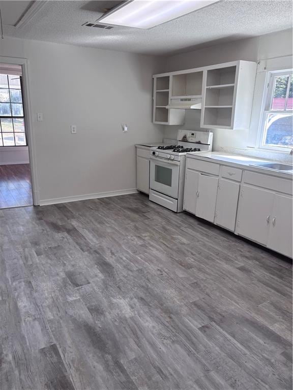 kitchen with white cabinetry, sink, dark hardwood / wood-style floors, and white gas range oven