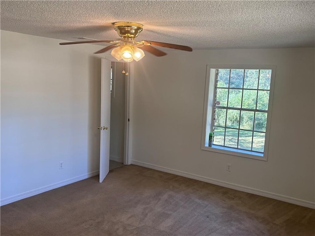 empty room with ceiling fan, carpet, and a textured ceiling