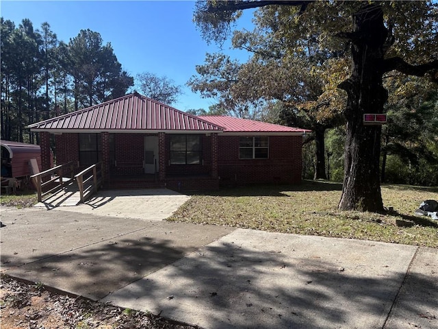 back of property with covered porch and a lawn