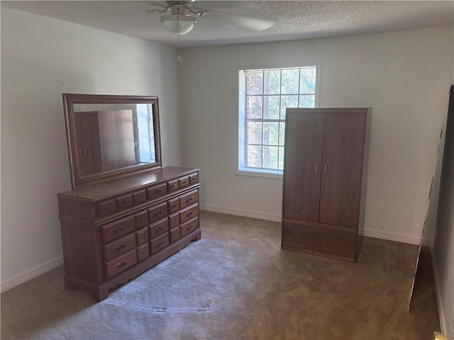 carpeted bedroom featuring ceiling fan and a textured ceiling