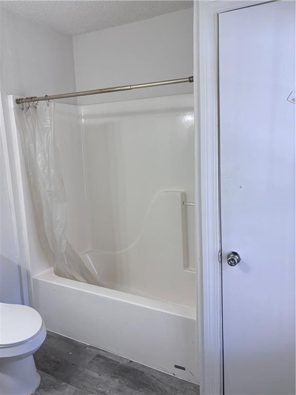 6830 Freedom Ln, Eight Mile, AL 36613 - full bathroom featuring shower / bath combo with shower curtain, toilet, wood finished floors, and a textured ceiling