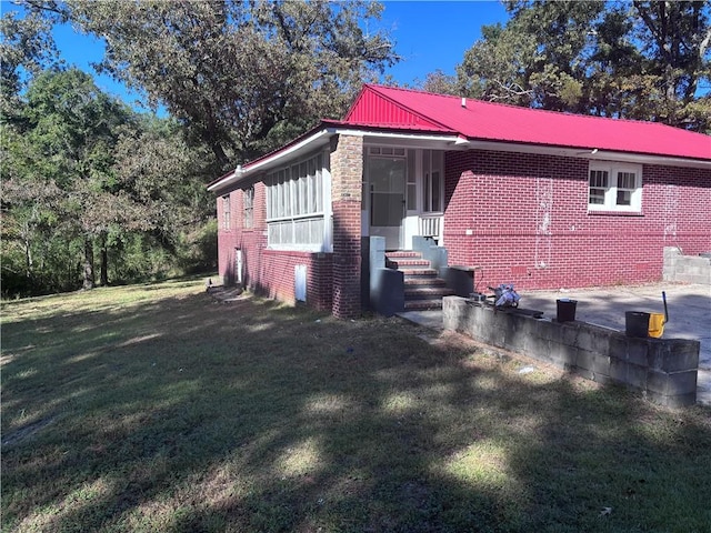 view of side of home featuring a patio and a lawn